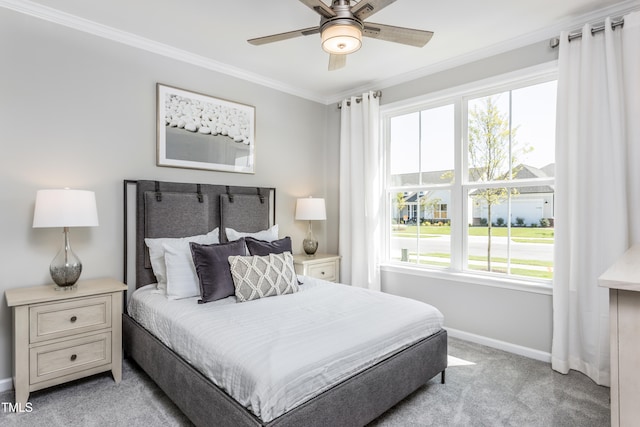 bedroom with light carpet, ceiling fan, baseboards, and crown molding