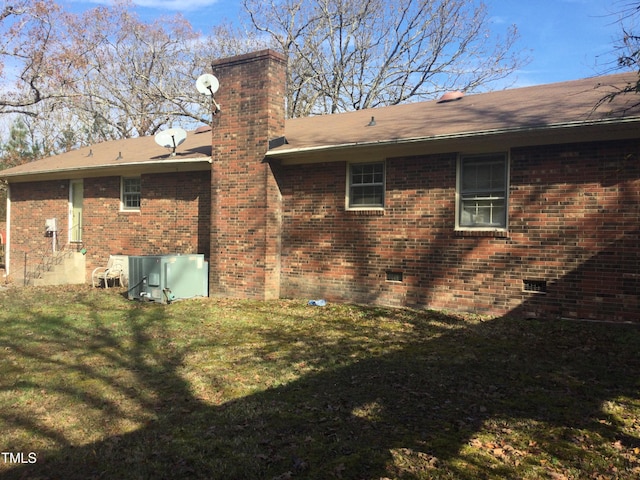 rear view of property with a lawn and cooling unit