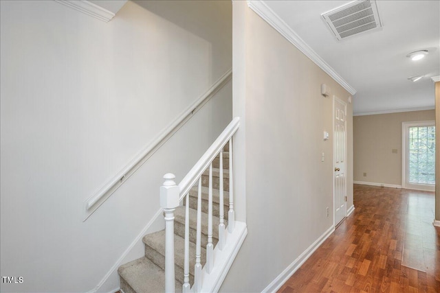 stairs featuring crown molding and wood-type flooring