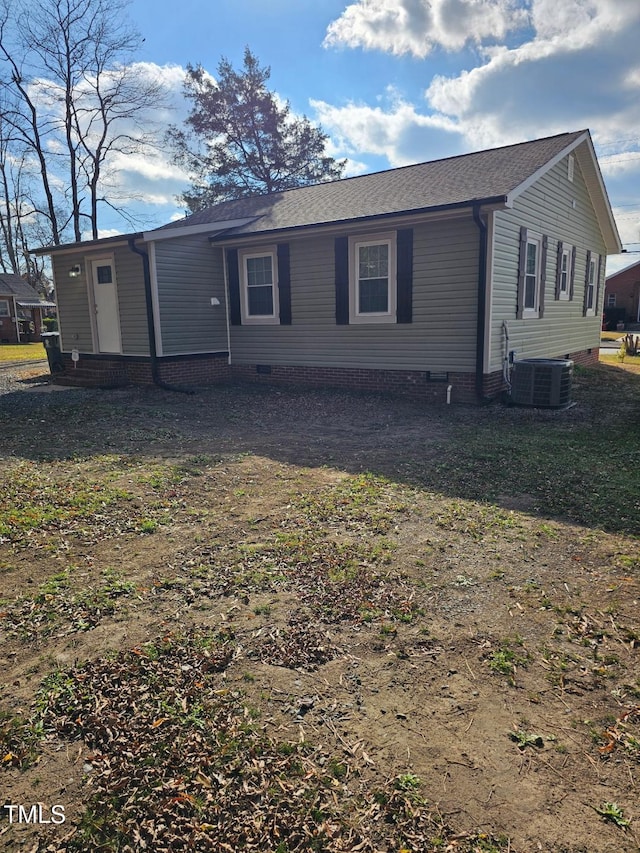 back of house with a lawn and central AC