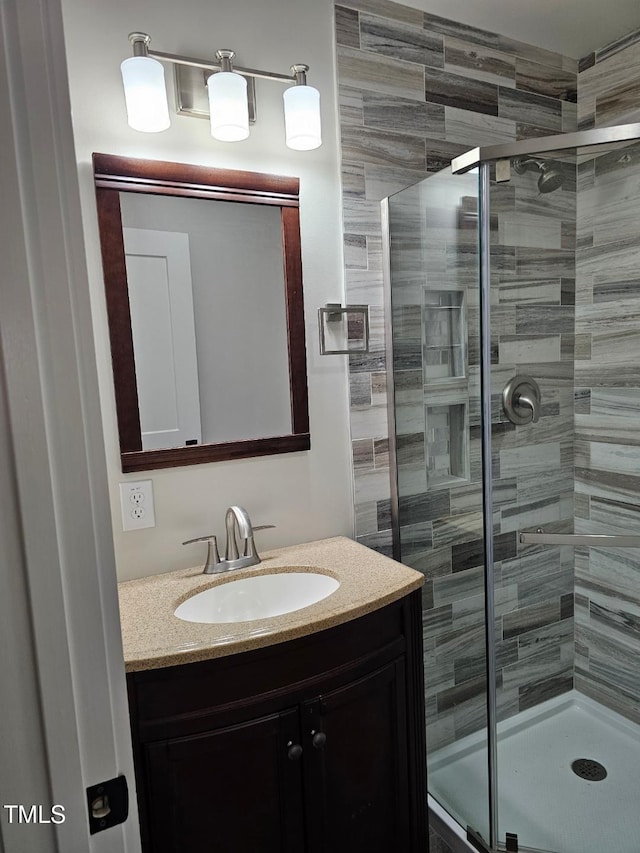 bathroom featuring vanity and a shower with shower door