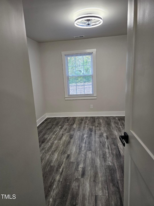 unfurnished room with dark hardwood / wood-style flooring