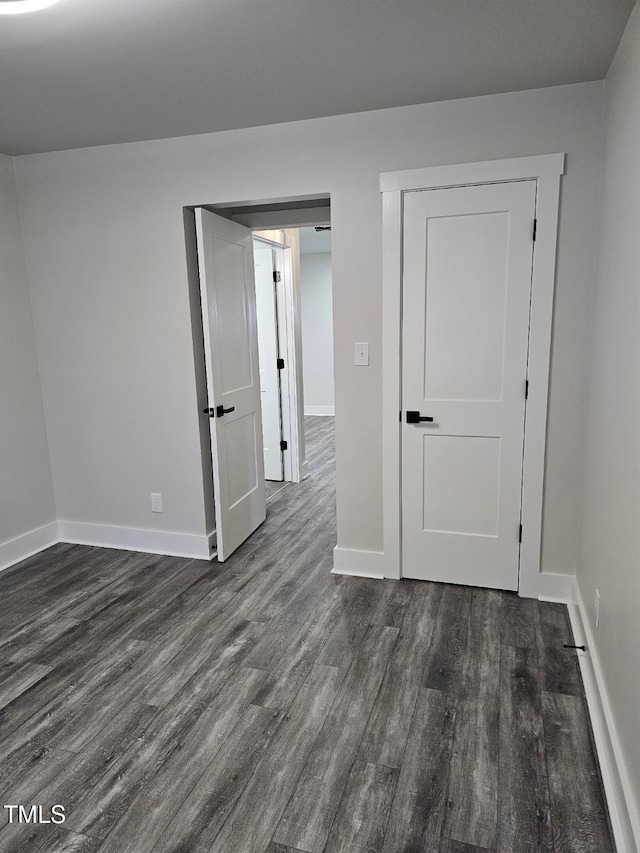 unfurnished room featuring dark wood-type flooring