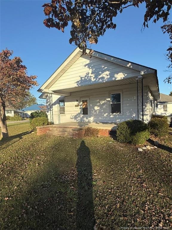 rear view of house featuring a lawn