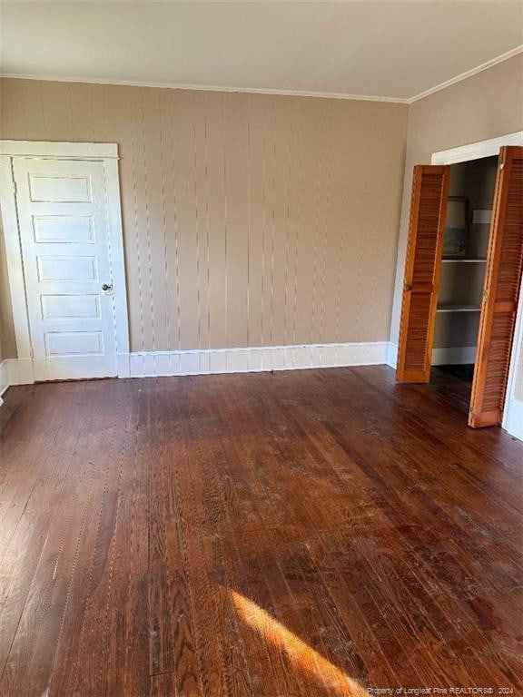 unfurnished bedroom with dark hardwood / wood-style floors and a closet