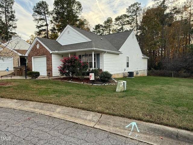 view of front of house with a garage, a front lawn, and cooling unit