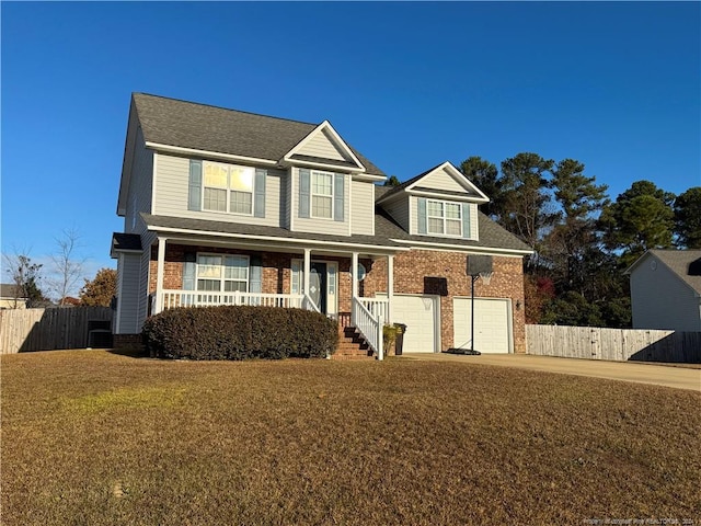 view of front of home featuring covered porch, a garage, and a front yard