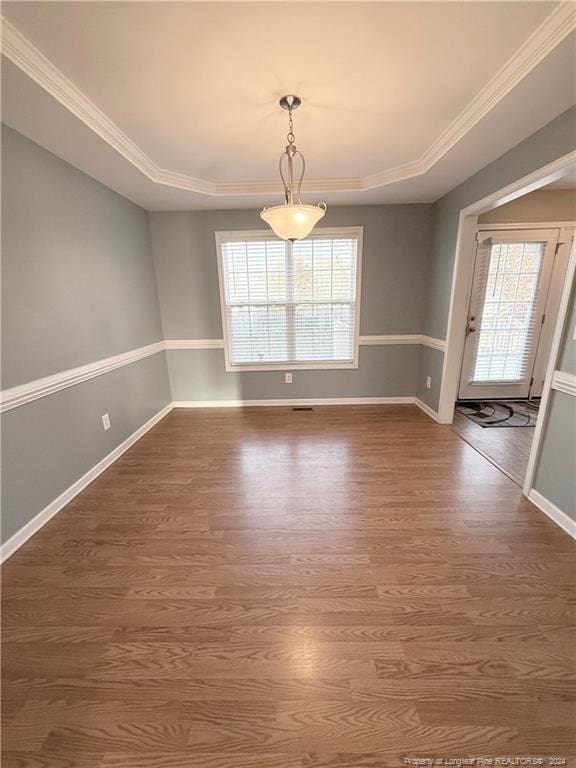 unfurnished dining area featuring crown molding, a healthy amount of sunlight, and dark hardwood / wood-style floors