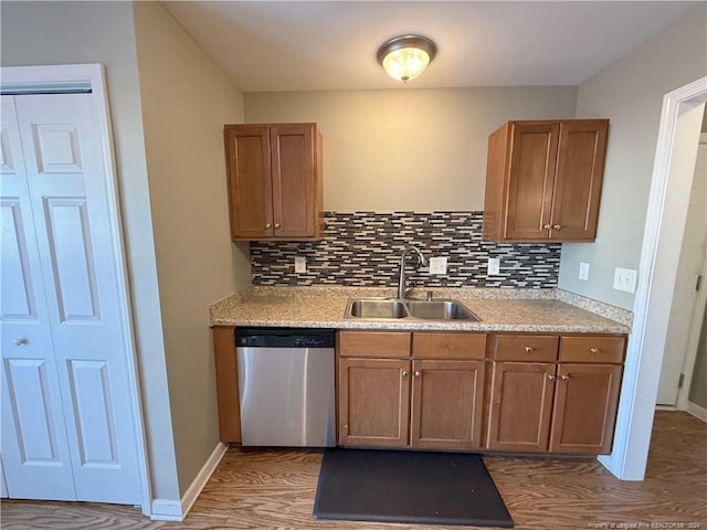 kitchen with hardwood / wood-style flooring, dishwasher, sink, and tasteful backsplash