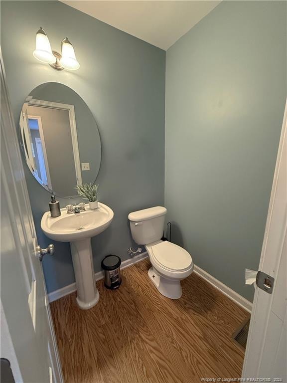 bathroom featuring hardwood / wood-style flooring and toilet