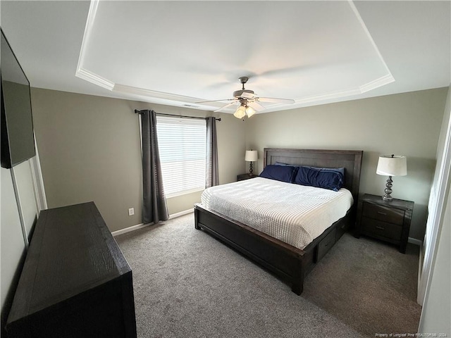 carpeted bedroom featuring a tray ceiling and ceiling fan