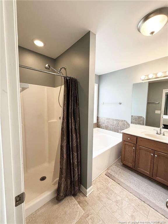 bathroom featuring vanity and independent shower and bath