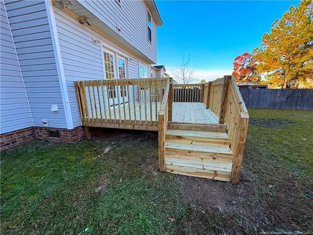 wooden terrace featuring a lawn