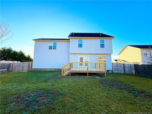 back of house featuring a lawn and a deck