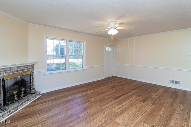 unfurnished living room featuring a fireplace, a textured ceiling, hardwood / wood-style flooring, and crown molding