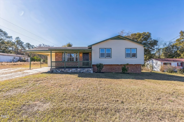 view of front of property featuring a front lawn, covered porch, and a carport