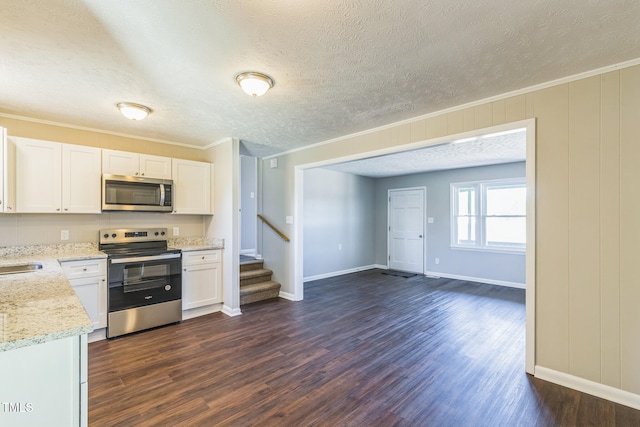 kitchen featuring white cabinets, crown molding, dark wood-type flooring, and appliances with stainless steel finishes