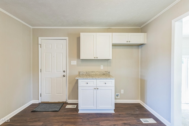 kitchen featuring light stone countertops, white cabinets, dark wood-type flooring, and ornamental molding