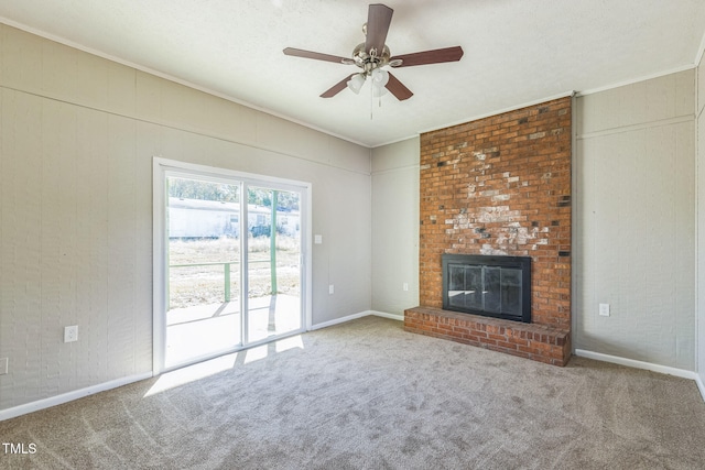 unfurnished living room with carpet flooring, ceiling fan, ornamental molding, and a fireplace