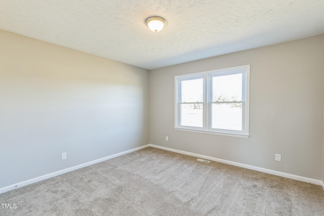 carpeted empty room with a textured ceiling