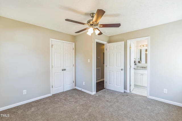 unfurnished bedroom with connected bathroom, ceiling fan, a closet, and light carpet