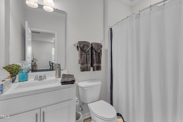 bathroom with vanity, toilet, and crown molding