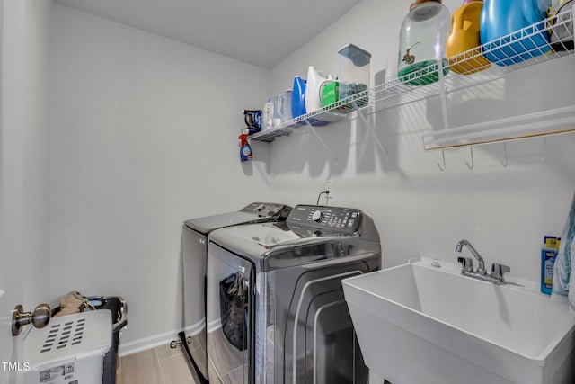 washroom featuring wood-type flooring, separate washer and dryer, and sink