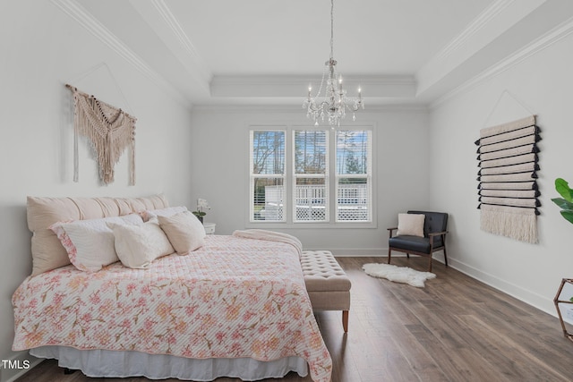 bedroom with a raised ceiling, wood-type flooring, ornamental molding, and a notable chandelier