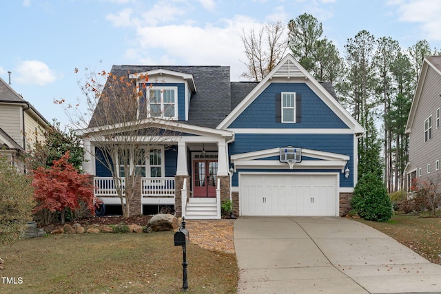 craftsman inspired home featuring a porch, a garage, and a front lawn