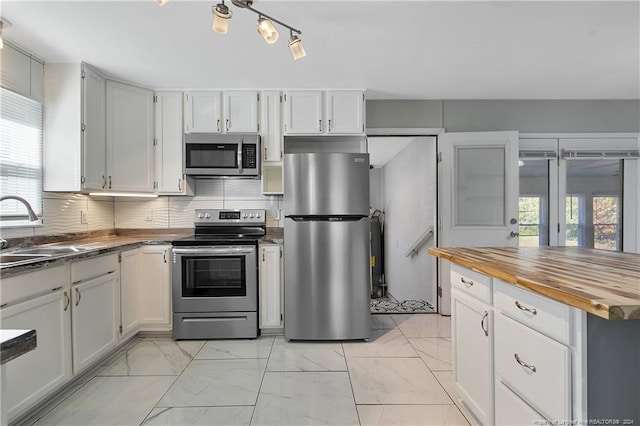 kitchen with white cabinets, stainless steel appliances, plenty of natural light, and sink