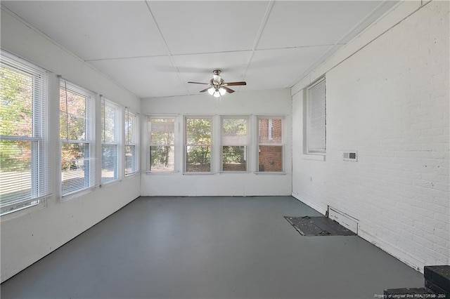 unfurnished sunroom featuring ceiling fan, a healthy amount of sunlight, and vaulted ceiling