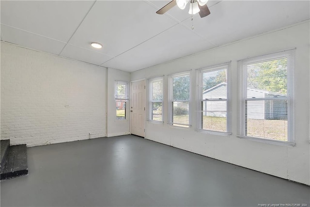 unfurnished sunroom with ceiling fan and a wealth of natural light