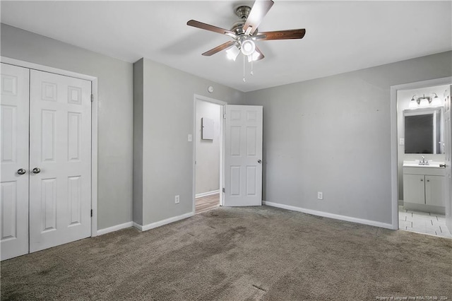 unfurnished bedroom with carpet, connected bathroom, ceiling fan, and sink