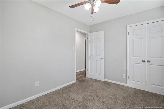 unfurnished bedroom featuring carpet, ceiling fan, and a closet