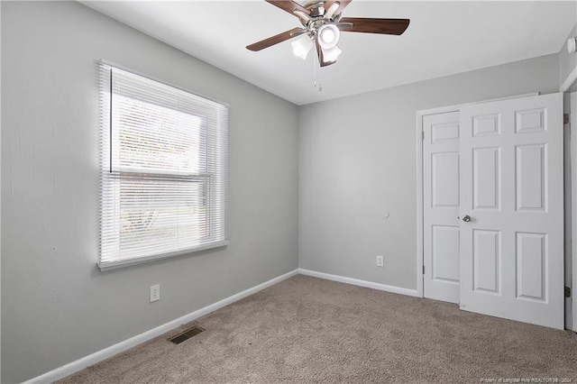 unfurnished room featuring ceiling fan and light colored carpet