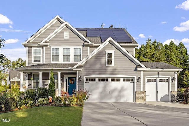 view of front of property featuring covered porch, solar panels, and a front yard