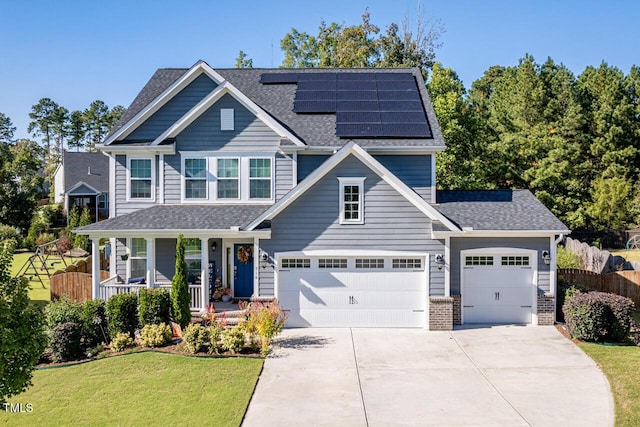 craftsman-style home featuring covered porch, solar panels, and a front yard