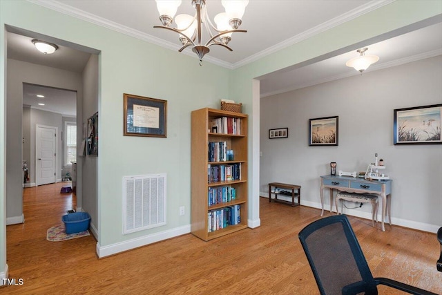 office area with light hardwood / wood-style flooring, ornamental molding, and an inviting chandelier