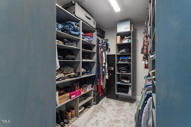 walk in closet featuring light carpet