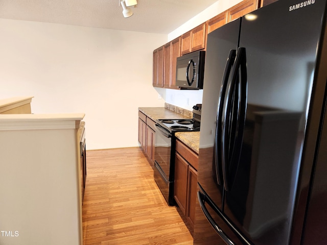 kitchen with black appliances and light wood-type flooring