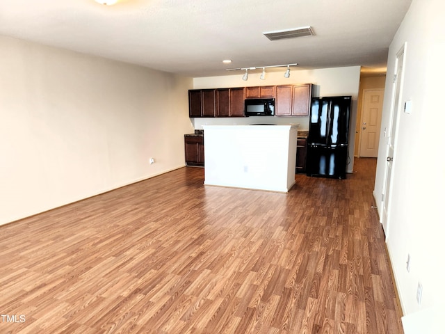 kitchen featuring black appliances, a center island, hardwood / wood-style floors, and track lighting