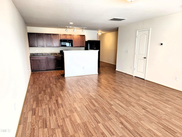 kitchen featuring rail lighting, dark brown cabinets, a kitchen island, black appliances, and hardwood / wood-style flooring