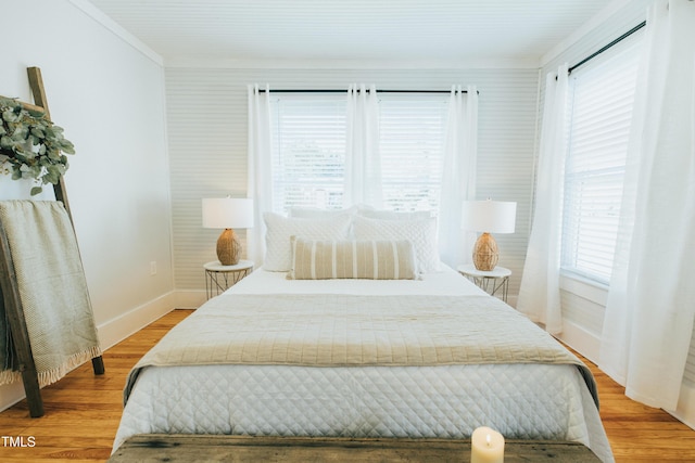 bedroom featuring light wood-type flooring and crown molding