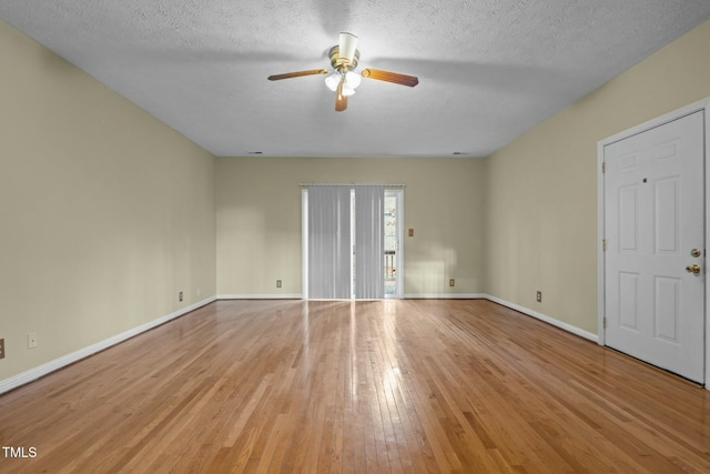 empty room featuring ceiling fan, light wood-type flooring, and a textured ceiling