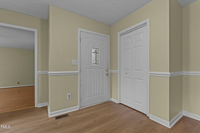 foyer entrance featuring light hardwood / wood-style floors and a textured ceiling