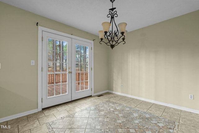 unfurnished dining area featuring a chandelier, light tile patterned floors, and french doors