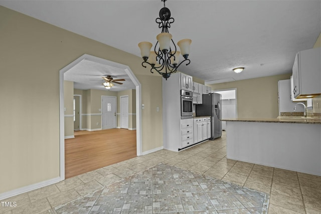 kitchen featuring white cabinetry, sink, light tile patterned flooring, ceiling fan with notable chandelier, and appliances with stainless steel finishes