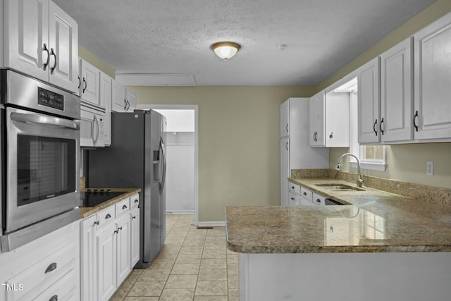 kitchen with kitchen peninsula, white cabinetry, sink, and appliances with stainless steel finishes