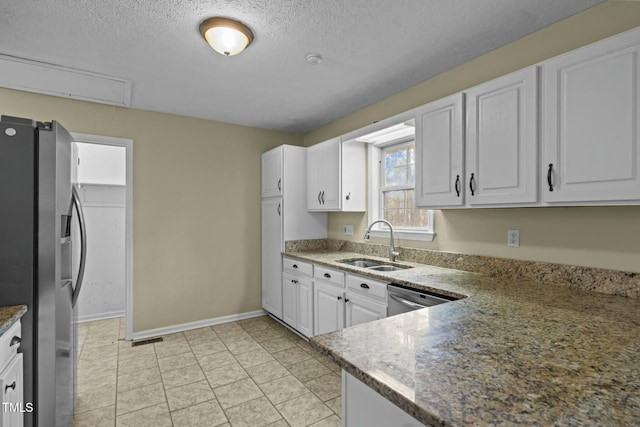 kitchen featuring a textured ceiling, stainless steel appliances, white cabinetry, and sink