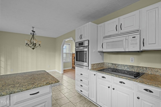 kitchen with decorative light fixtures, stainless steel oven, white cabinetry, and black electric cooktop